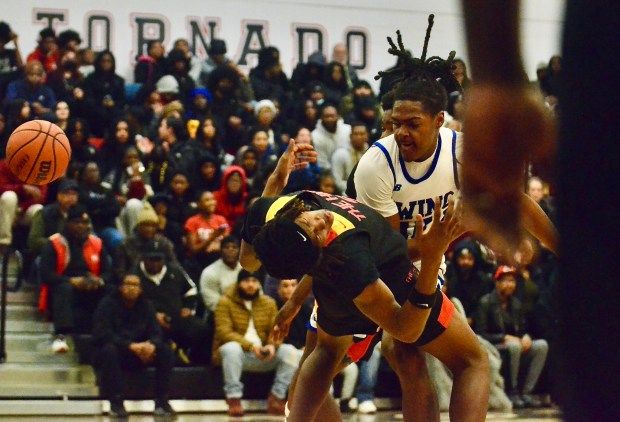 Ewing’s Shawn Robertson, right, knocks over Trenton High’s Aivaye Ingram,...