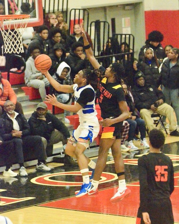 Ewing’s Davion Morton, left, tries to lay the ball in...